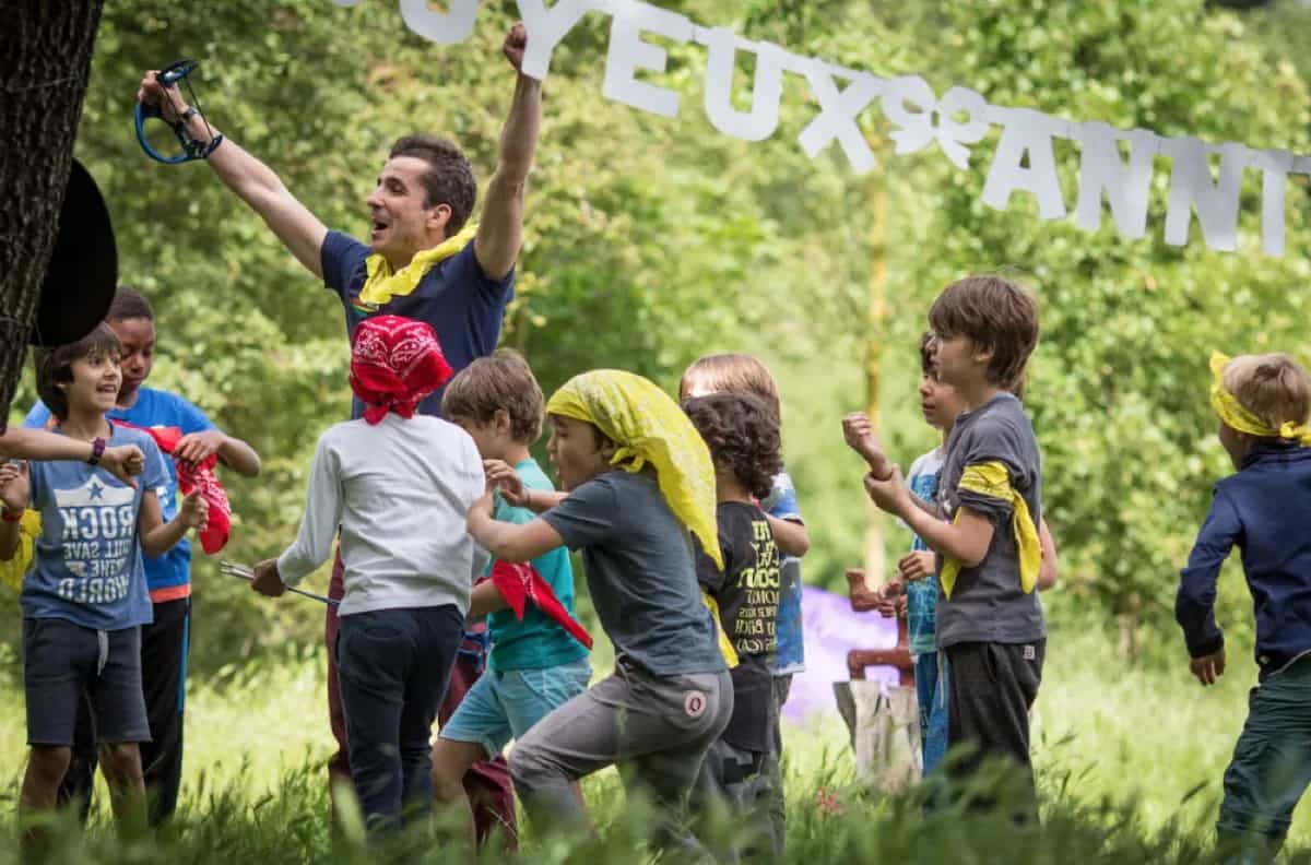 A Kidays host setting up a team challenge for children in a park