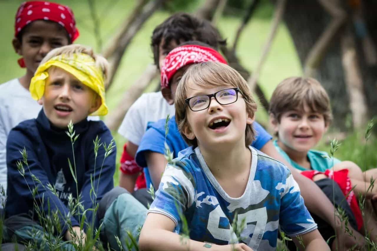 Animateur Kidays et enfants bras levés pendant une épreuve d’équipe en extérieur